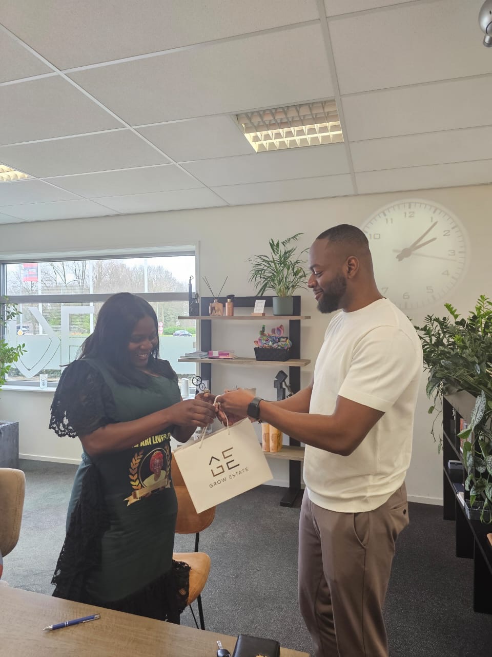 Denzel overhandigt een Grow Estate tas aan een klant